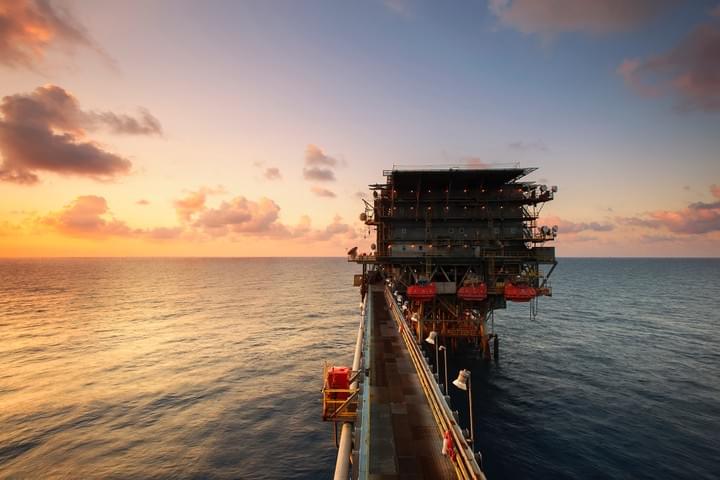 Offshore oil production platform at sunset